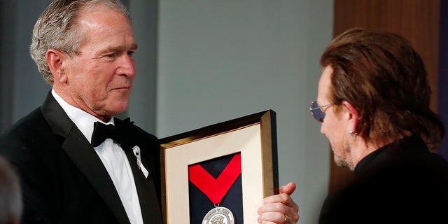 Former President George W. Bush, left, presents a medal of Distinguished Leadership to U2 musician Bono during a gala for the Forum on Leadership at the George W. Bush Institute, Thursday, April 19, 2018, in Dallas.