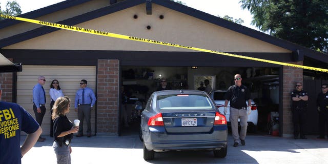 A car is backed out of the garage of a home searched in connection with the arrest of a man on suspicion of murder, Wednesday, April 25, 2018, in Citrus Heights, Calif.