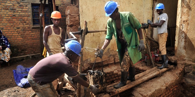 Residents excavate at the site of a recently-discovered mass grave in Gasabo district, near the capital Kigali, in Rwanda.
