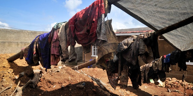 Clothes of genocide victims whose bodies were exhumed last week hang outside at the site of a recently-discovered mass grave in Gasabo district, near the capital Kigali, in Rwanda.