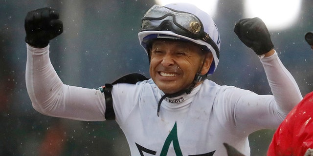 Mike Smith celebrates after riding Justify to victory.