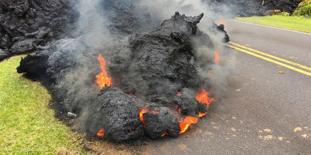Lava from the Kilauea volcano moves across the road in the Leilani Estates in Pahoa, Hawaii, Saturday, May 5, 2018.