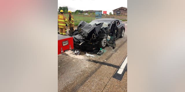 In this Friday, May 11, 2018, photo released by the South Jordan Police Department shows a traffic collision involving a Tesla Model S sedan with a Fire Department mechanic truck stopped at a red light in South Jordan, Utah. Witnesses indicated the Tesla Model S did not brake prior to impact. Police Sgt. Samuel Winkler said the car's air bags were activated and that the Tesla's 28-year-old driver suffered a broken right ankle, while the driver of the mechanic truck didn't require treatment. Police in a Salt Lake City suburb say it's not immediately known whether a Tesla Model S sedan's semi-autonomous Autopilot driving system was in use when it rear-ended a truck apparently without braking before impact at approximately 60 mph. (South Jordan Police Department via AP)