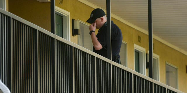 A DeKalb County law enforcement officer stands outside a guest room at the United Inn and Suites Hotel Saturday.