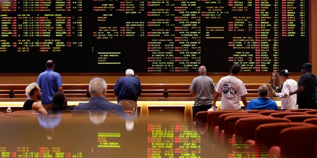 People line up to place bets in the sports book at the South Point hotel-casino, Monday, May 14, 2018, in Las Vegas. The Supreme Court on Monday gave its go-ahead for states to allow gambling on sports across the nation, striking down a federal law that barred betting on football, basketball, baseball and other sports in most states. (AP Photo/John Locher)