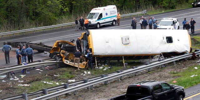 Emergency personnel work at the scene of a school bus and dump truck collision, injuring multiple people, on Interstate 80 in Mount Olive, N.J., Thursday, May 17, 2018.