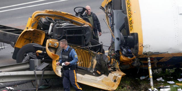 Emergency personnel examine a school bus after it collided with a dump truck, injuring multiple people, on Interstate 80 in Mount Olive, N.J., Thursday, May 17, 2018.