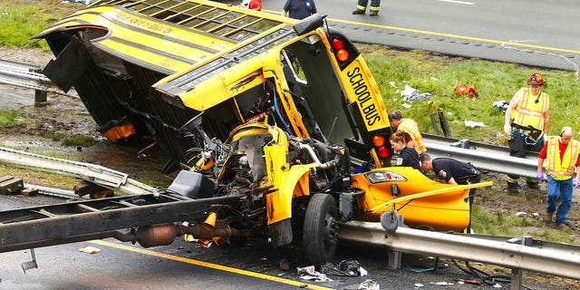 Emergency personnel examine a school bus after it collided with a dump truck, injuring multiple people, on Interstate 80 in Mount Olive, N.J., Thursday, May 17, 2018.