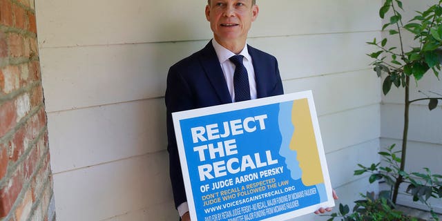 Aaron Persky holds a "Reject the Recall" placard in Los Altos Hills, Calif., May 15, 2018. (Associated Press)