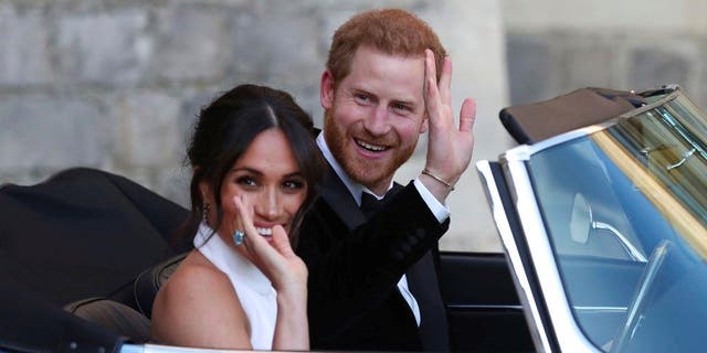 The newly married Duke and Duchess of Sussex Meghan Markle and Prince Harry leave Windsor Castle in a convertible car after their wedding in Windsor England to attend an evening reception at Frogmore House hosted by the Prince of Wales Saturday May