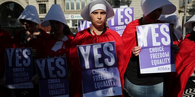Volunteers from Reproductive rights, against Oppression, Sexism & Austerity (ROSA) dressed as characters from 'The Handmaid's Tale', demonstrate in Dublin, May 23, 2018.