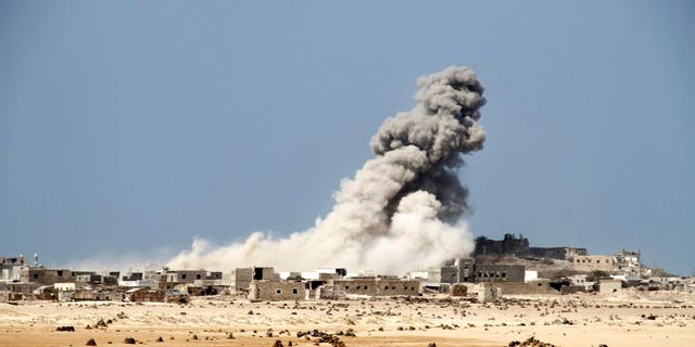 An explosion raises a cloud as coalition-backed fighters advance on the Red Sea port town of Mocha in Yemen in this Jan. 11, 2017, photo, part of a campaign that eventually recaptured the town from Shiite Houthi rebels.