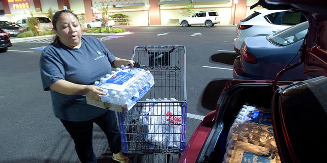 Juana Francisco of Albany, Ore., loads her trunk with water purchased at WinCo, May 29, 2018.