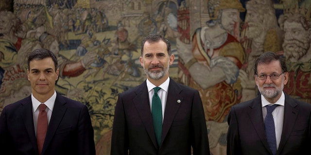 Spain's socialist leader Pedro Sanchez, left, poses with King Felipe VI, center and former Prime Minister Mariano Rajoy after the swearing in ceremony at the Zarzuela Palace on the outskirts of Madrid, Spain.