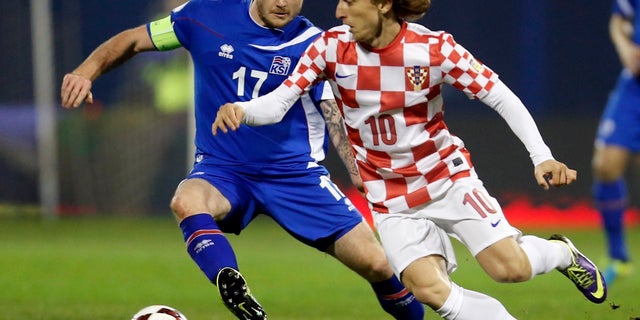 Iceland's Aron Gunnarsson, left, is challenged by Croatia's Luka Modric during their World Cup qualifying playoff in 2013.