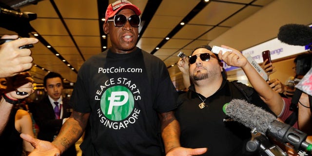 Former NBA basketball player Dennis Rodman, and Chris Volo, right, arrive at Singapore's Changi Airport on Tuesday.