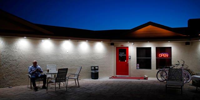 In this April 27, 2018 photo, Dennis Hof sits in front of the Love Ranch brothel in Crystal, Nevada.