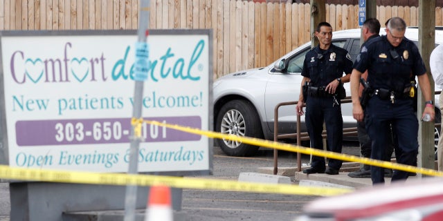 Law enforcement officials investigate the scene of a shooting in a parking lot behind Colorado's dentist's office. Thursday, June 14, 2018, in Westminster, Colo.