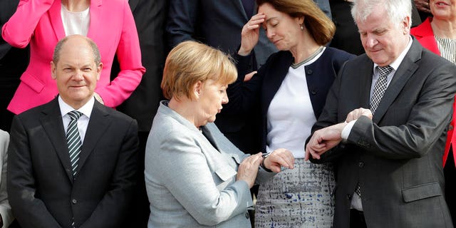 Time’s up? Angela Merkel and Horst Seehofer look at their watcher while they were posing for a group photo in April