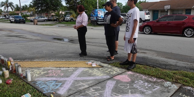Fans and mourners of rap singer XXXTentacion pause by a memorial, Tuesday, June 19, 2018, outside Riva Motorsports in Deerfield Beach, Fla., where the troubled rapper-singer was killed the day before.