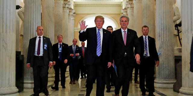 President Donald Trump, center, accompanied by House Majority Leader Kevin McCarthy of Calif., waves as he departs Capitol Hill in Washington, Tuesday, June 19, 2018, after a meeting to rally Republicans around a GOP immigration bill. (AP Photo/Alex Brandon)