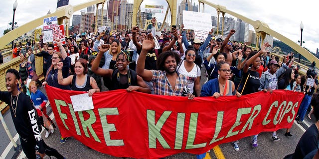Protestors cross the Roberto Clemente bridge during a evening rush hour march that began in downtown Pittsburgh Friday
