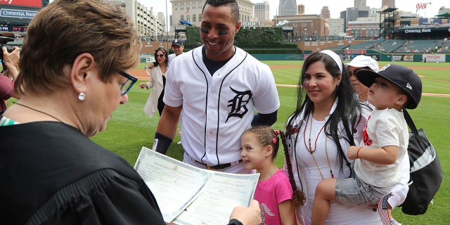 Judge Marianne Battani prepares to give Detroit Tigers center fielder Leonys Martin and his wife Yaimira their naturalization papers after a ceremony before a baseball game, in Detroit.