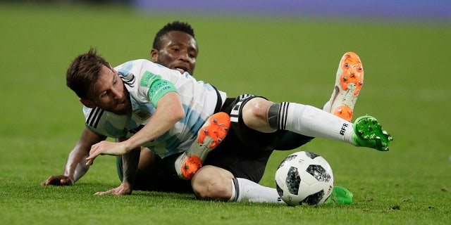 Argentina's Lionel Messi, foreground, and Nigeria's John Obi Mikel compete for the ball during the group D match between Argentina and Nigeria.