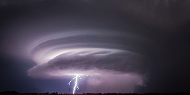 A lightning bolt emerges from a severe thunderstorm just west of Wichita, Kansas.