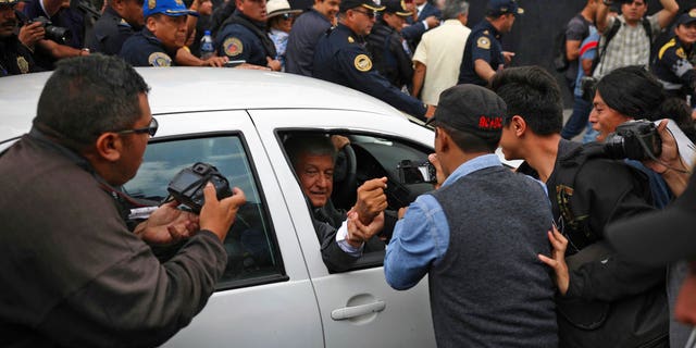 Mexico's President-elect Andres Manuel Lopez Obrador greets a supporter as he leaves the National Palace where he met with Mexico's President Enrique Pena Nieto in Mexico City, Tuesday, July 3, 2018.