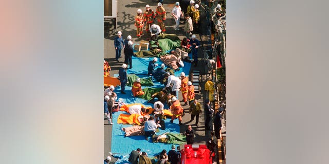 In this March 20, 1995, file photo, the injured of the deadly gas attack are treated by rescuers near Tsukiji subway station in Tokyo.