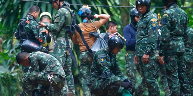 Thai rescuers prepare to enter the cave where 12 boys and their soccer coach have been trapped since June 23