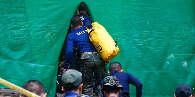 Rescuers arrive near the cave where 12 boys and their soccer coach have been trapped since June 23, in Mae Sai, Chiang Rai province, in northern Thailand Sunday, July 8, 2018.