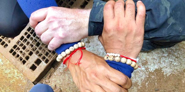 Thailand Navy SEAL posted on Facebook showing rescuers locking hands with a caption reading: "We Thai and the international teams join forces to bring the young Wild Boars home."