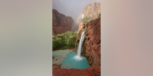 A rainbow appears over a waterfall on the Havasupai reservation in Supai, Ariz., Wednesday, July 11, 2018.