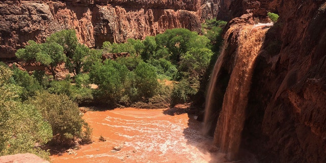 Waterfalls normally blue-green turned muddy brown in Supai, Ariz., after flooding the area, July 11, 2018.