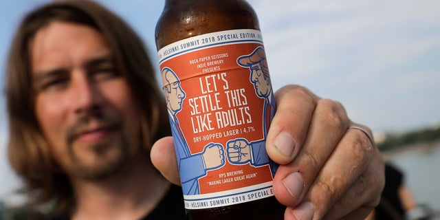 Samuli Huuhtanen, CEO of Finnish brewery Rock Paper Scissors, displays a bottle of "Let's Settle this Like Adults," a beer inspired by Monday's scheduled Trump-Putin summit.