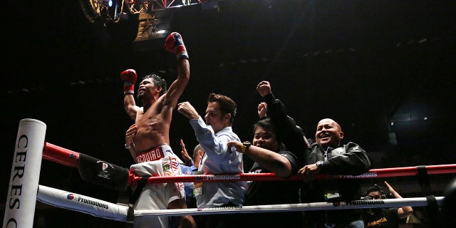 Manny Pacquiao of the Philippines, left, celebrates after defeating Lucas Matthysse of Argentina during their WBA World welterweight title bout in Kuala Lumpur, Malaysia
