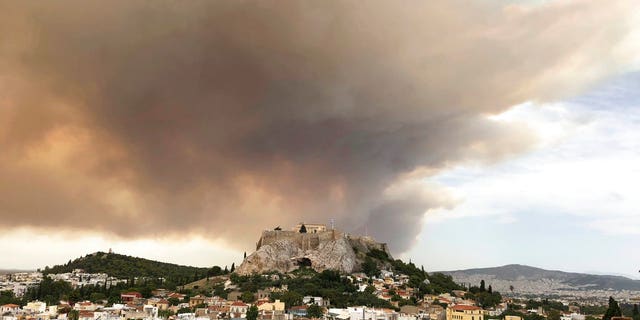 At least 20 people have been killed and dozens more injured as two huge wildfires burned outside of Athens, Greece, officials announced Tuesday.