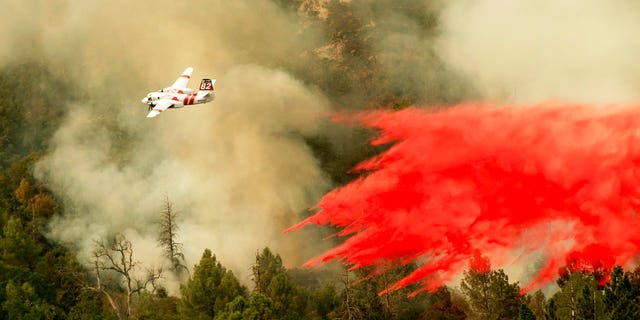 An air tanker drops retardant while fighting to stop the Ferguson Fire from reaching homes in the Darrah community of unincorporated Mariposa Count, Calif., Wednesday, July 25, 2018.