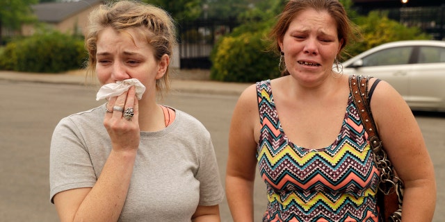 Sherry Bledsoe, left, cries next to her sister, Carla, outside of the sheriff's office after hearing news that Sherry's children, James and Emily, and grandmother, Melody Bledsoe, were killed in a wildfire Saturday, July 28, 2018, in Redding, Calif.
