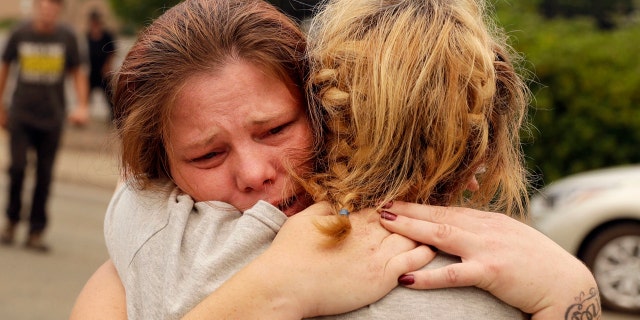 Carla Bledsoe, facing camera, hugs her sister Sherry outside of the sheriff's office after hearing news that Sherry's children James, 4, and Emily 5, and grandmother were killed in a wildfire Saturday, July 28, 2018, in Redding, Calif.