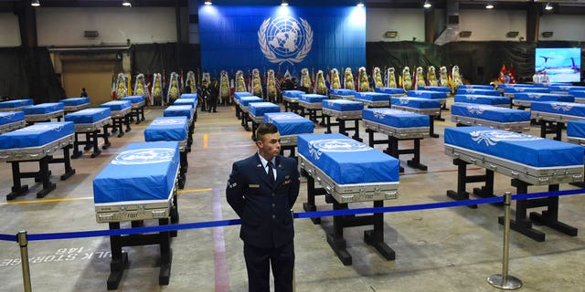 A U.S. airman stands guard next to caskets containing remains of U.S. soldiers killed in the Korean War and collected in North Korea before a repatriation ceremony at Osan Air Base in Pyeongtaek, South Korea, on Wednesday, Aug. 1, 2018.