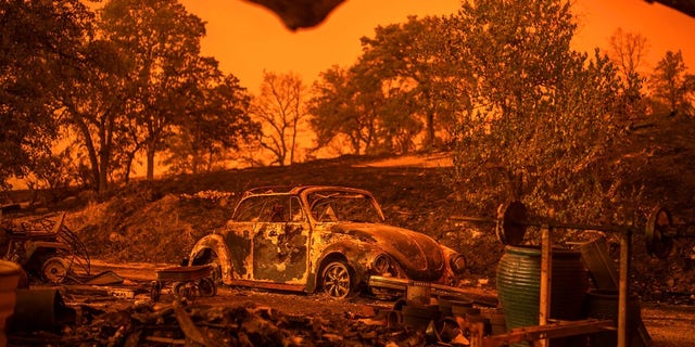 A Volkswagen Beetle scorched by a wildfire called the Carr Fire rests at a residence in Redding.