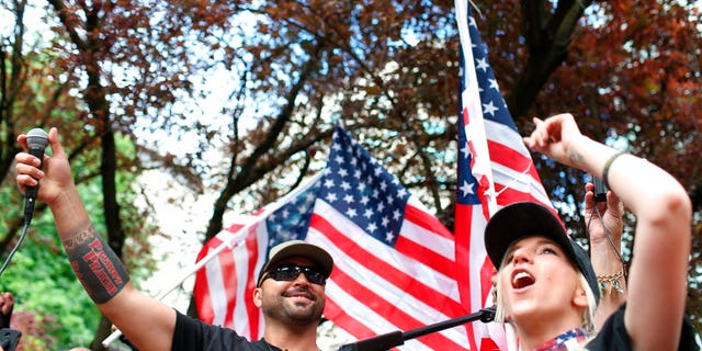 FILE--In this June 30, 2018, file photo, Joey Gibson, left, leader of Patriot Prayer, heads the group's rally in Portland, Ore. Portland is bracing for what could be another round of violent clashes Saturday, Aug. 4, 2018, between a right-wing group holding a rally here and self-described anti-fascist counter-protesters who have pledged to keep Patriot Prayer and other affiliated groups out of this ultra-liberal city. (Mark Graves/The Oregonian via AP, file)