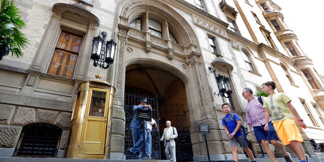 People walk by the entrance to the Dakota Apartments, in New York on Aug. 15, 2018, where John Lennon was shot by Mark Chapman in 1980.