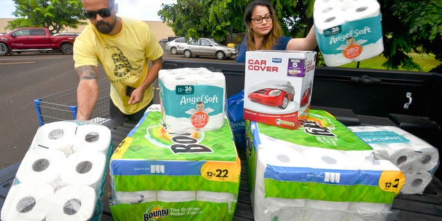 Bryce and Dom Boeder of Waimea, Kauai, load their truck with storm supplies in the parking lot of a Walmart store in Lihue, on the island of Kauai, Hawaii, Tuesday, Aug. 21, 2018.