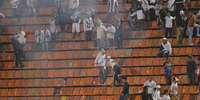 Police stand next to fans of Argentina's Independiente at the end of a Copa Libertadores soccer match against Brazil's Santos