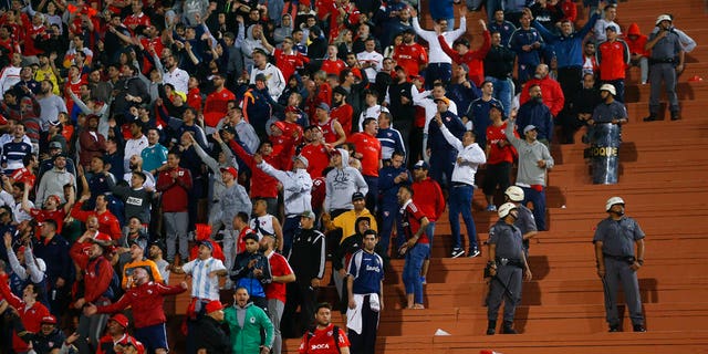 Police stand next to fans of Argentina's Independiente at the end of a Copa Libertadores soccer match against Brazil's Santos