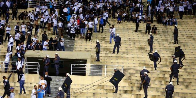 Police order the fans of Brazil's Santos to leave the grandstand after fights broke out in the stands at the end of a Copa Libertadores soccer match